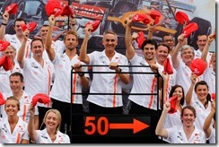 Jenson Button, Martin Whitmarsh and Sergio Perez lift thier 50th Anniversary Flat Caps during a team picture.